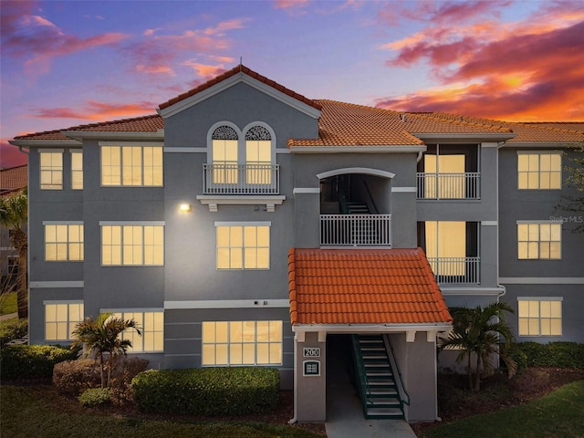 exterior space featuring a tiled roof and stucco siding