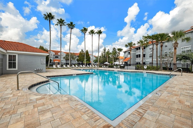 pool with fence and a patio