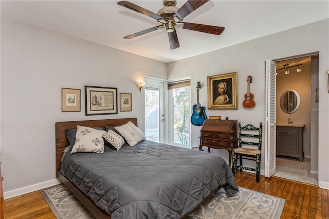 bedroom with ceiling fan, ensuite bathroom, hardwood / wood-style flooring, baseboards, and access to exterior