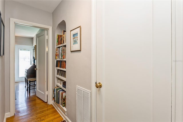 hallway with wood finished floors and visible vents