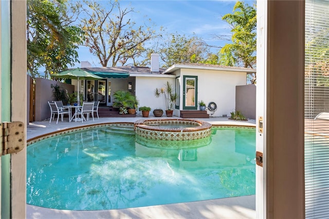 view of swimming pool featuring a patio and a pool with connected hot tub