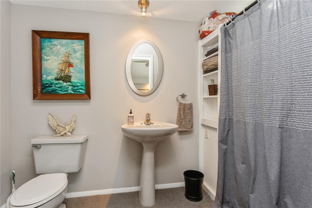 full bath with curtained shower, baseboards, a sink, and toilet