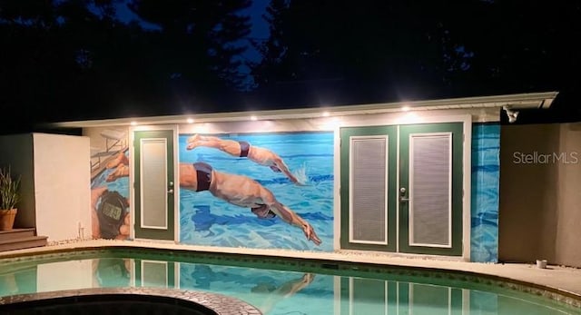 exterior space featuring an indoor pool, french doors, and an in ground hot tub