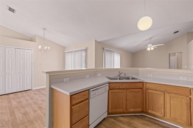 kitchen featuring lofted ceiling, decorative light fixtures, dishwasher, and sink