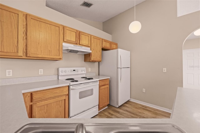 kitchen with white appliances, decorative light fixtures, light hardwood / wood-style flooring, and a textured ceiling