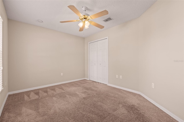 empty room with ceiling fan, carpet, and a textured ceiling