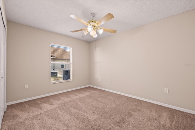 carpeted empty room featuring ceiling fan and a textured ceiling