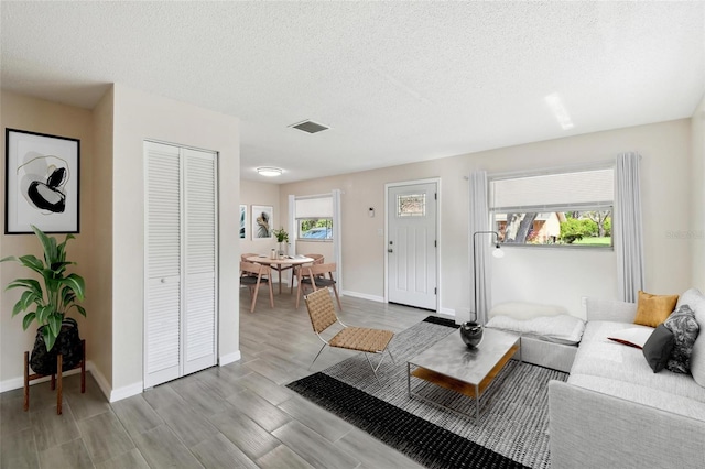 living room featuring light hardwood / wood-style floors and a textured ceiling