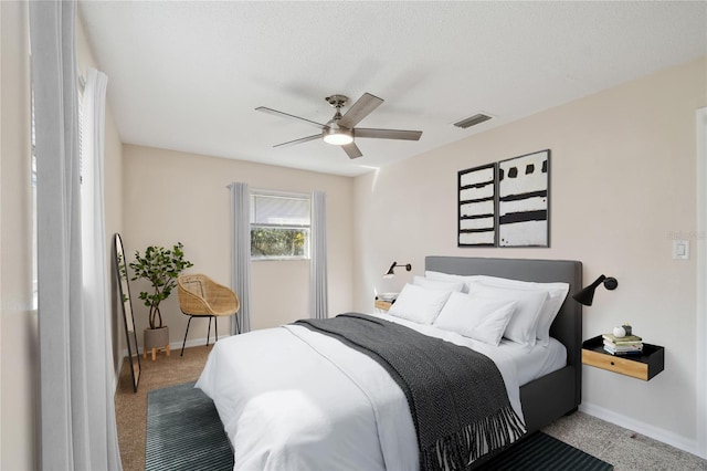 carpeted bedroom featuring a textured ceiling and ceiling fan