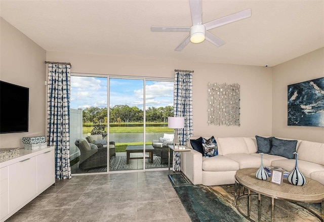 living room featuring ceiling fan and a water view