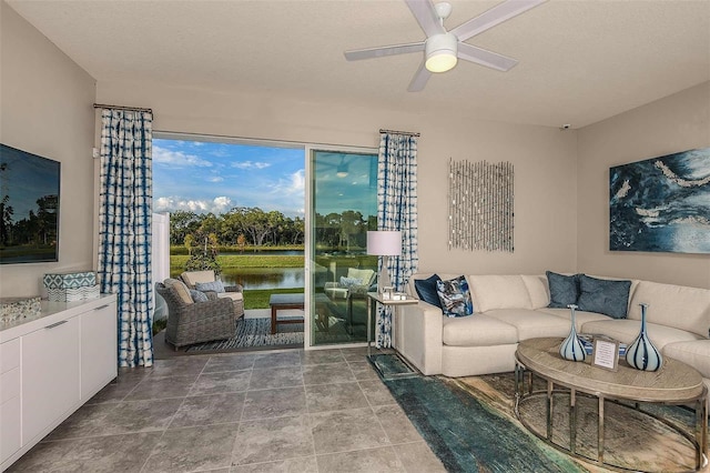 living room featuring a water view, a textured ceiling, and ceiling fan