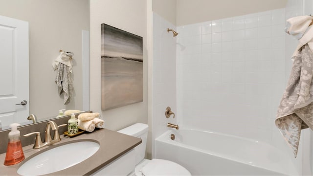 full bathroom featuring tiled shower / bath, vanity, and toilet