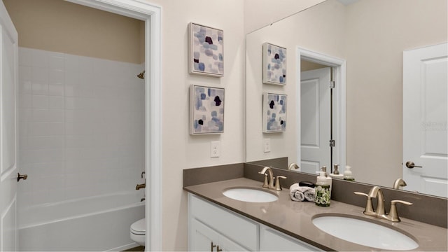 full bathroom with tiled shower / bath, vanity, and toilet