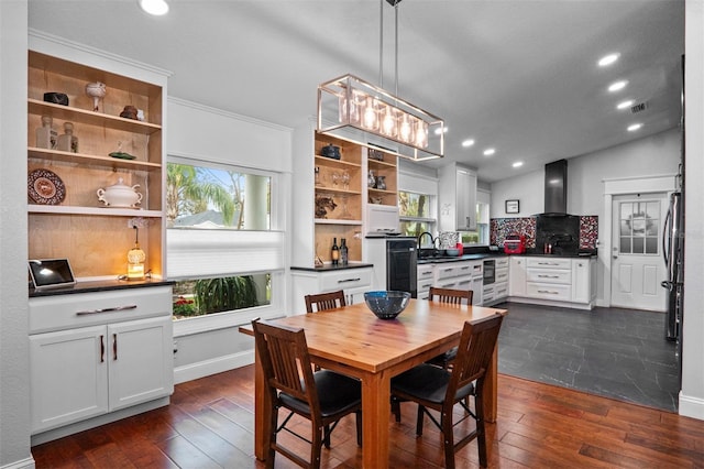 dining area with wine cooler, a healthy amount of sunlight, vaulted ceiling, and dark hardwood / wood-style flooring