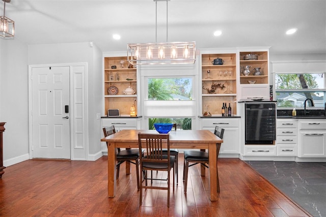 dining room featuring sink, dark wood-type flooring, and wine cooler