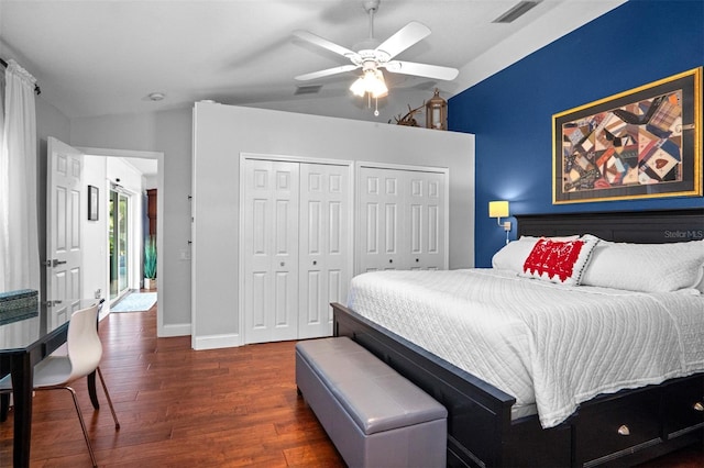 bedroom with ceiling fan, dark hardwood / wood-style floors, and two closets