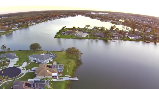 aerial view at dusk featuring a water view