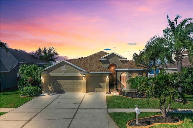 view of front of house featuring a garage and a lawn