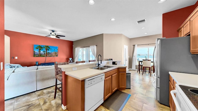 kitchen featuring dishwasher, sink, a kitchen bar, stove, and a center island