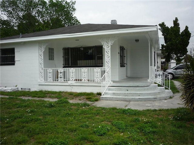 view of front of home with a front yard and covered porch