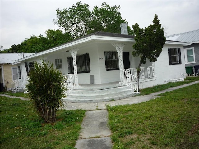 view of front of property with covered porch and a front yard