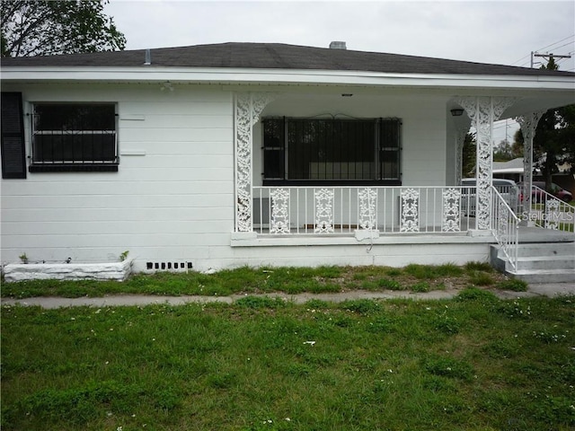 view of side of property featuring a yard and covered porch