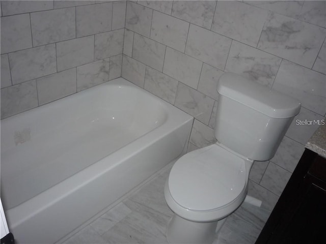 bathroom with a tub to relax in and toilet