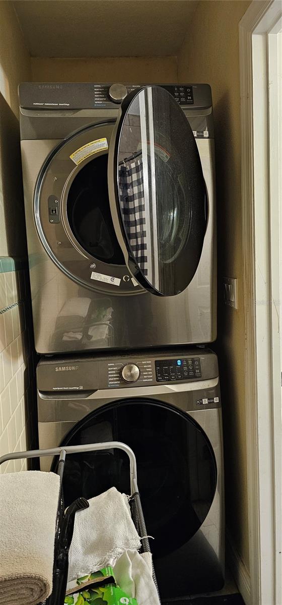 clothes washing area featuring stacked washer / drying machine