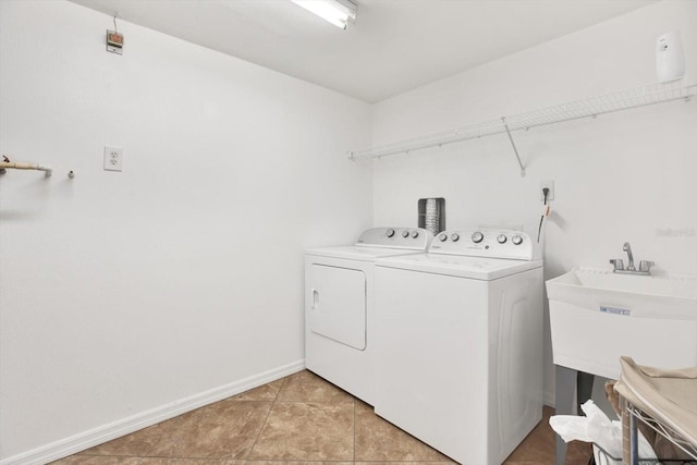 laundry area with washer and dryer, sink, and light tile patterned floors