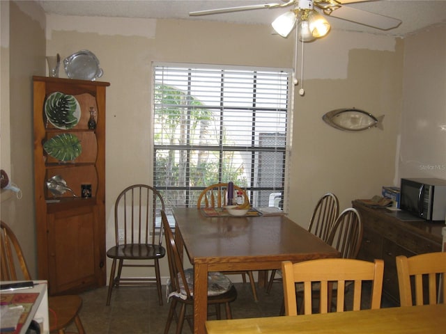 dining space with tile patterned flooring and ceiling fan