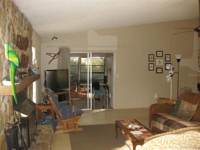 living room with lofted ceiling, ceiling fan, and a textured ceiling