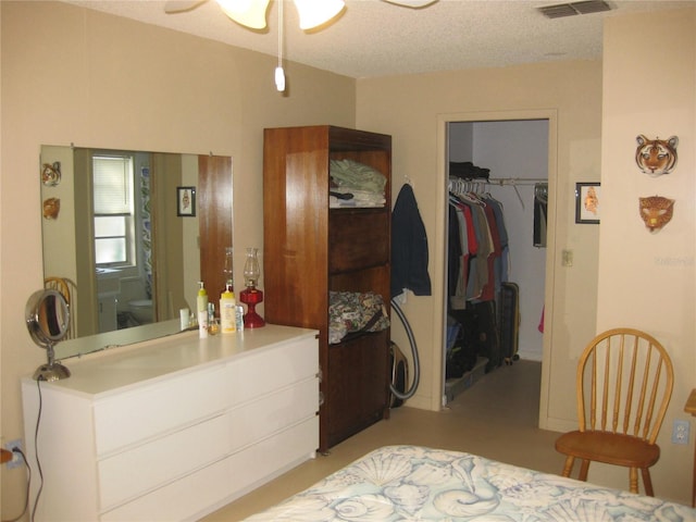 bedroom featuring a spacious closet, a textured ceiling, and a closet