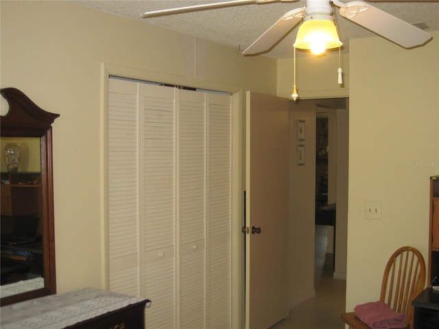 interior space featuring ceiling fan, a closet, and a textured ceiling