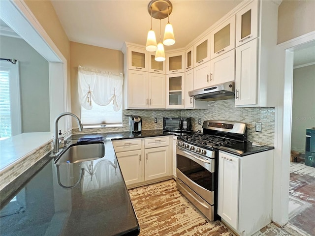 14124 Plum Ln, Hudson, FL 34667 - kitchen with gas stove, under cabinet range hood, a sink, and backsplash