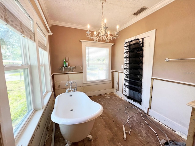 14124 Plum Ln, Hudson, FL 34667 - full bath featuring a chandelier, a freestanding tub, a textured ceiling, and ornamental molding