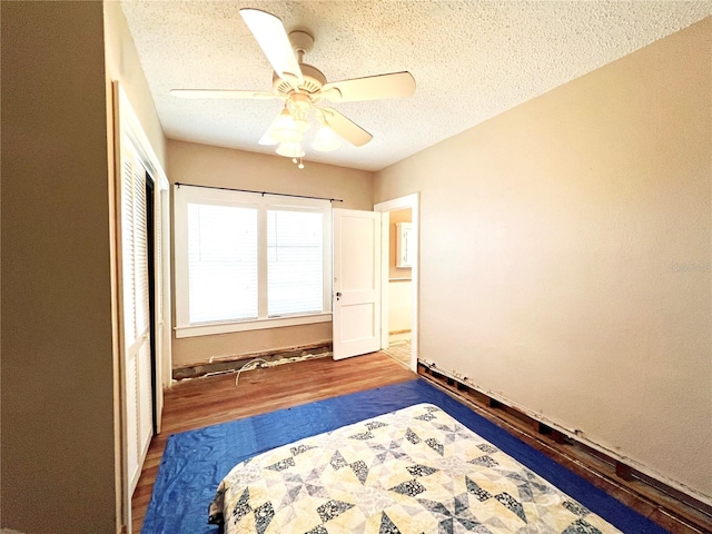 14124 Plum Ln, Hudson, FL 34667 - bedroom with wood finished floors, a textured ceiling, a closet, and a ceiling fan