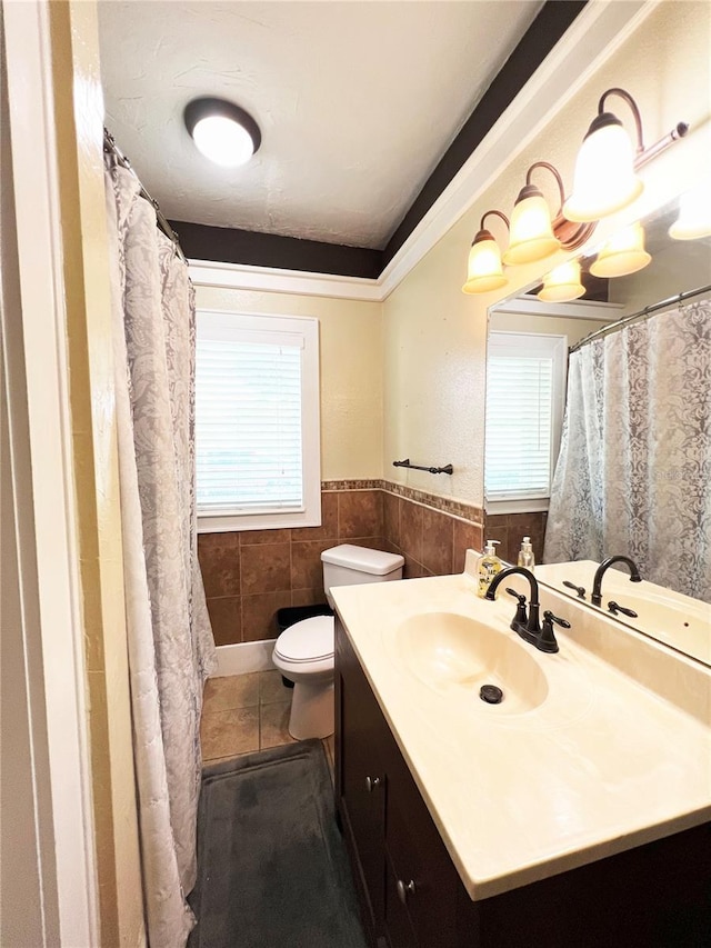 14124 Plum Ln, Hudson, FL 34667 - full bath with toilet, vanity, wainscoting, tile walls, and tile patterned flooring