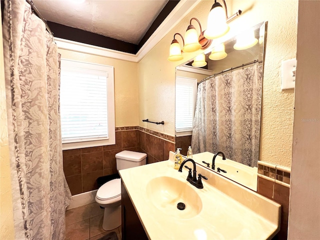 14124 Plum Ln, Hudson, FL 34667 - full bath with toilet, tile patterned flooring, tile walls, wainscoting, and vanity
