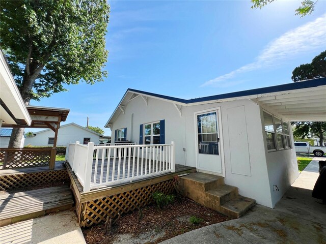 14124 Plum Ln, Hudson, FL 34667 - view of home's exterior featuring a wooden deck and stucco siding