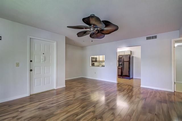 unfurnished living room featuring dark wood-type flooring and ceiling fan