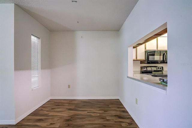 unfurnished room with dark hardwood / wood-style flooring and plenty of natural light