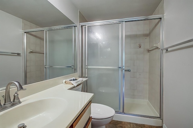 bathroom featuring vanity, an enclosed shower, and toilet