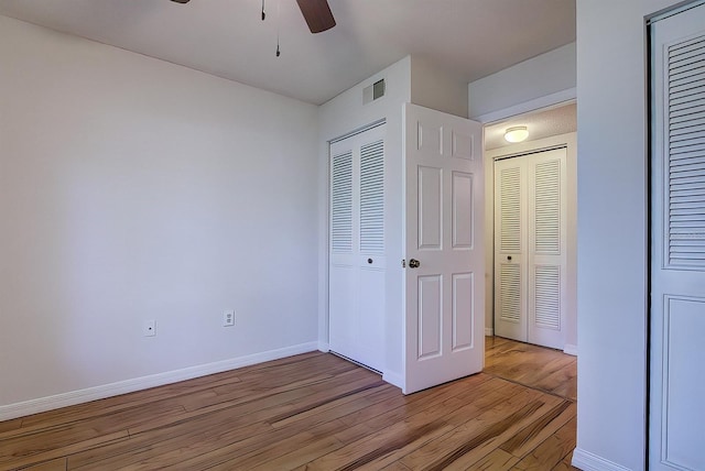 unfurnished bedroom featuring light hardwood / wood-style flooring, a closet, and ceiling fan