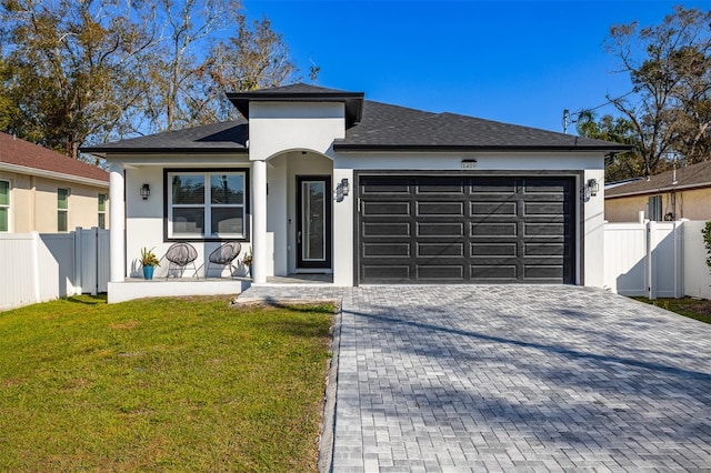 view of front of home with a garage, covered porch, and a front yard