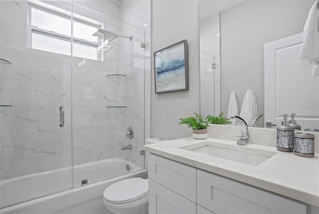 full bathroom with vanity, shower / bath combination with glass door, and toilet