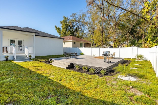 view of yard with a wooden deck and french doors