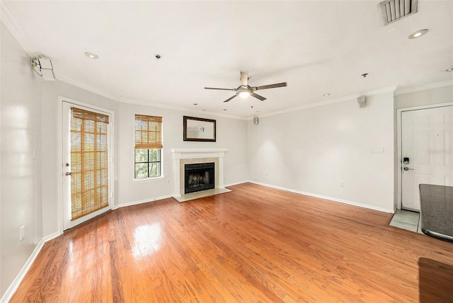 unfurnished living room with ornamental molding, ceiling fan, and light wood-type flooring