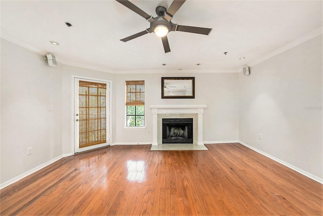 unfurnished living room with hardwood / wood-style floors, crown molding, and ceiling fan