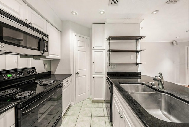 kitchen featuring white cabinetry, sink, light tile patterned flooring, and electric range