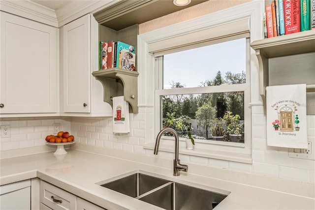 kitchen with open shelves, light countertops, decorative backsplash, white cabinets, and a sink